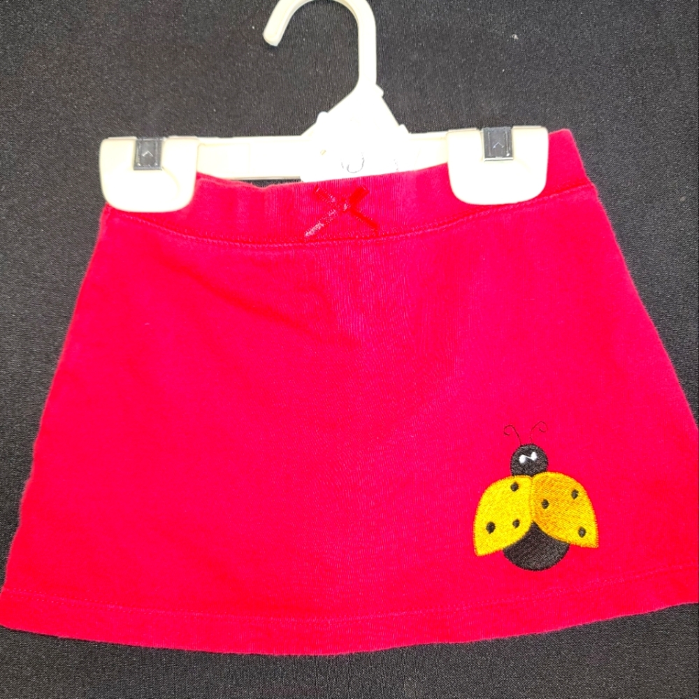 Cute red skort with a bumble bee embroidered on it